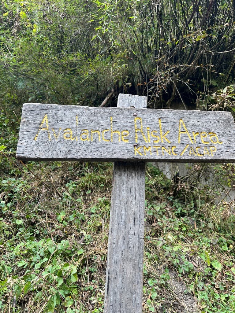 Weathered wooden Avalanche Risk Area sign on the Annapurna Base Camp trail