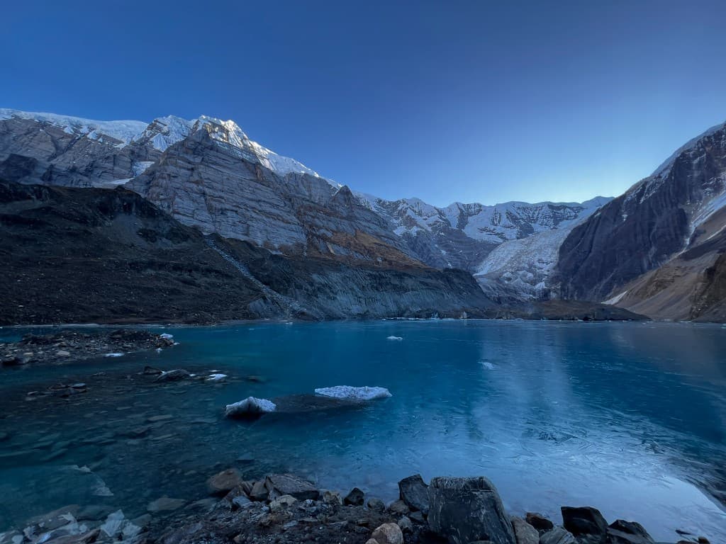 Early morning ice and turquoise water at Pancha Kunda Lake, North ABC