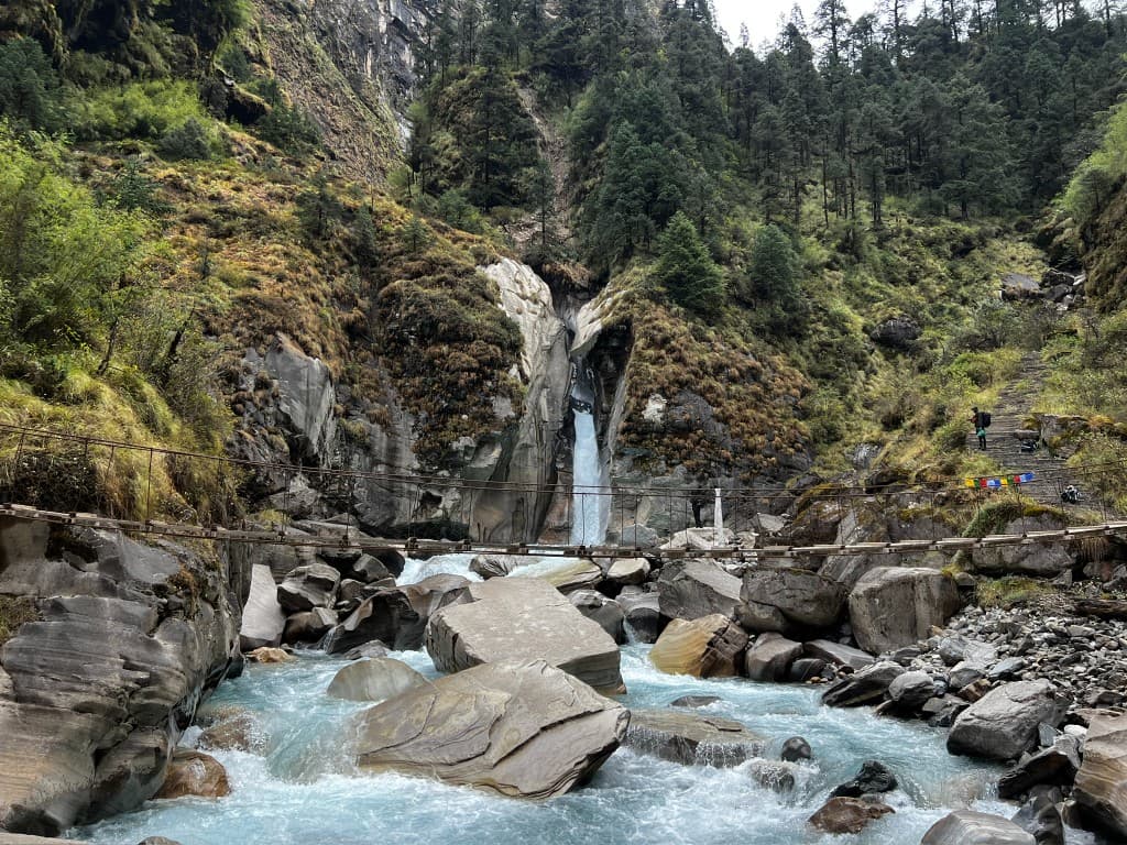 Phutphute Waterfall and suspension bridge over turquoise glacial river
