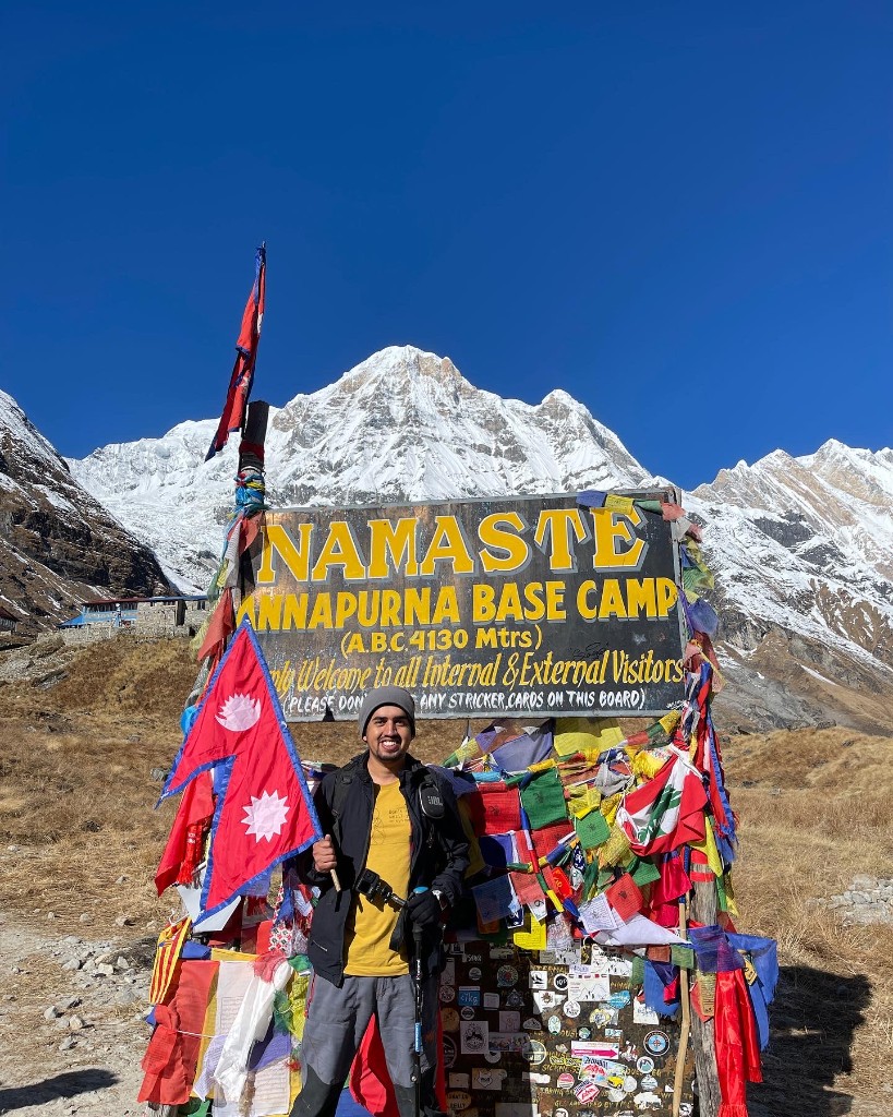 Pratap Sharma with a Nepali flag at the Namaste Annapurna Base Camp 4130 m sign