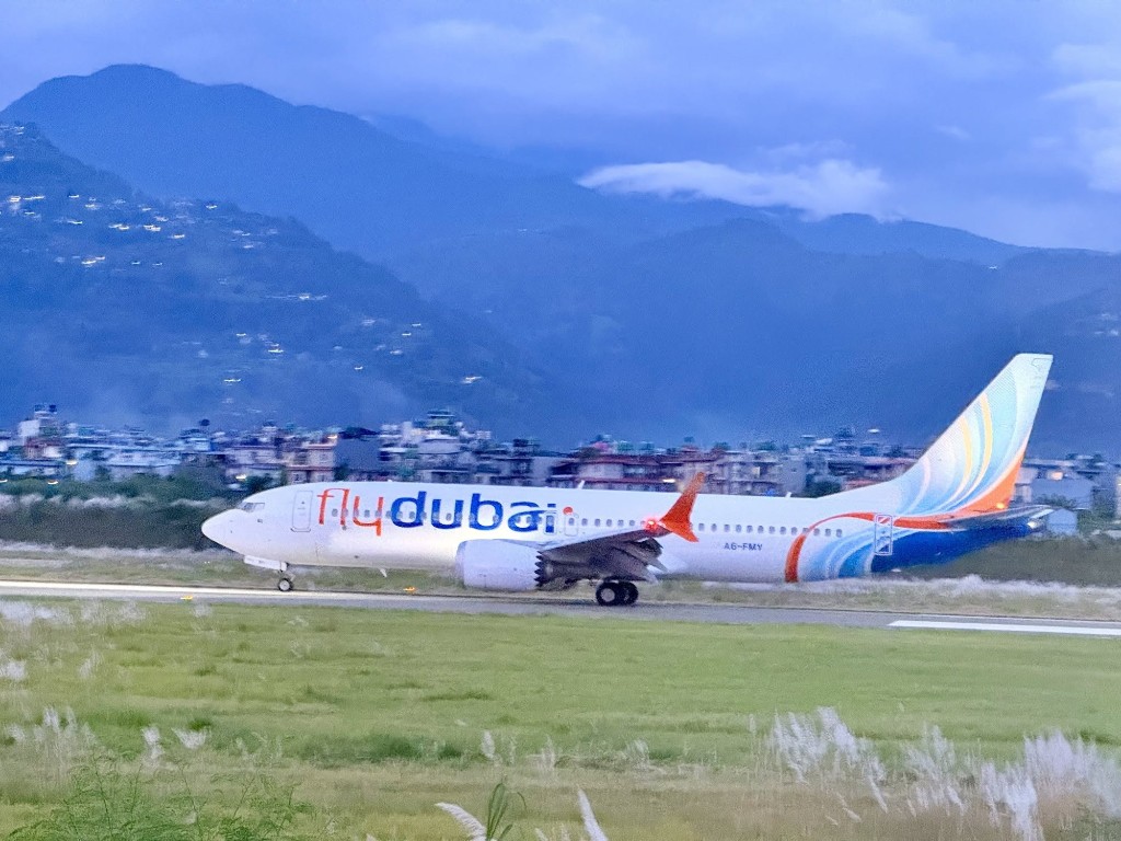 flydubai aircraft on the ground at Pokhara with the city and hills behind the runway
