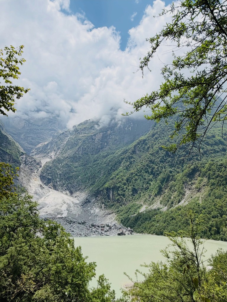 Kapuche Lake framed by forest and glacier moraine