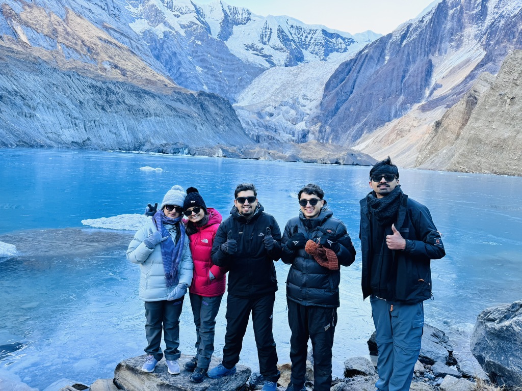 Trekkers posing at turquoise Pancha Kunda Lake on the North ABC trek
