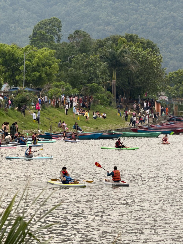 Lakeside shore at Phewa Lake with docked boats and paddleboard rentals