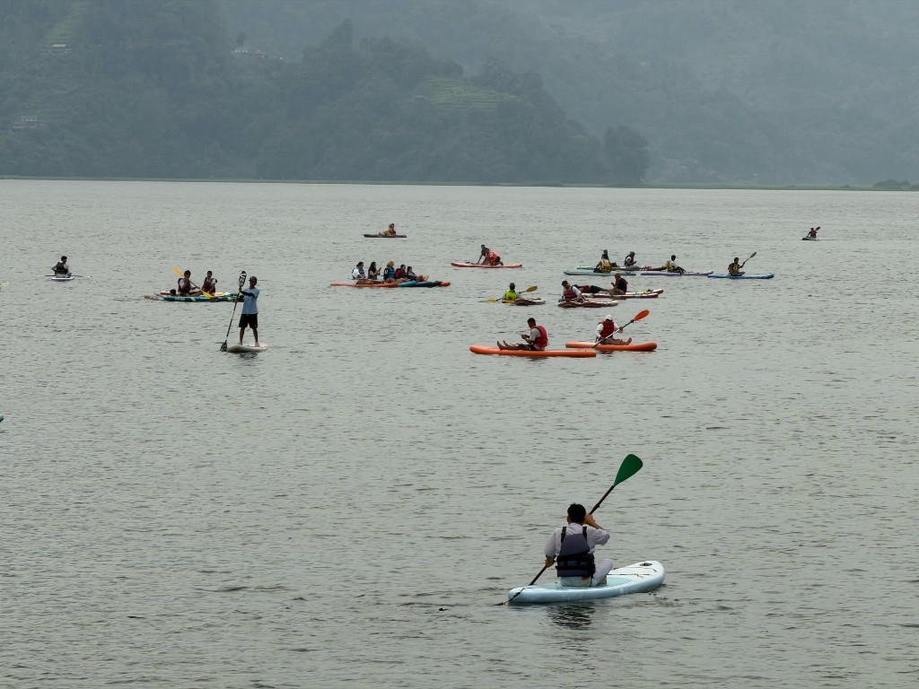Wide view of SUP and kayak rentals spread across Phewa Lake with terraced green hills
